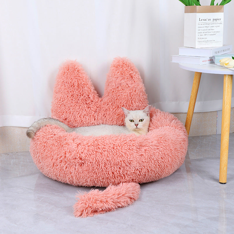 Cat lying in cozy plush pink cat bed 