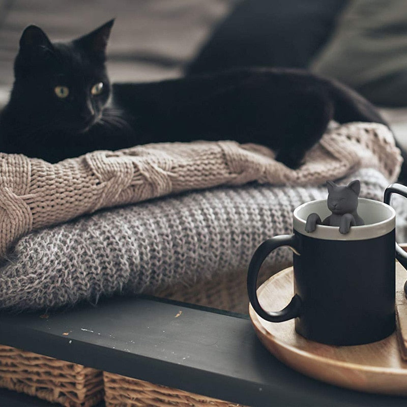 Cat looking at mug with Cat-tea infuser 