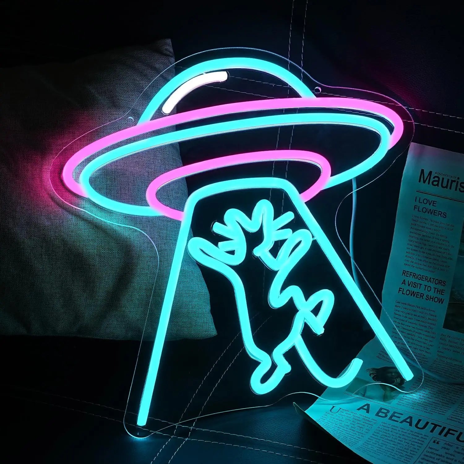 Vibrant neon sign of a UFO abducting a cat, glowing in pink, blue, and white hues.