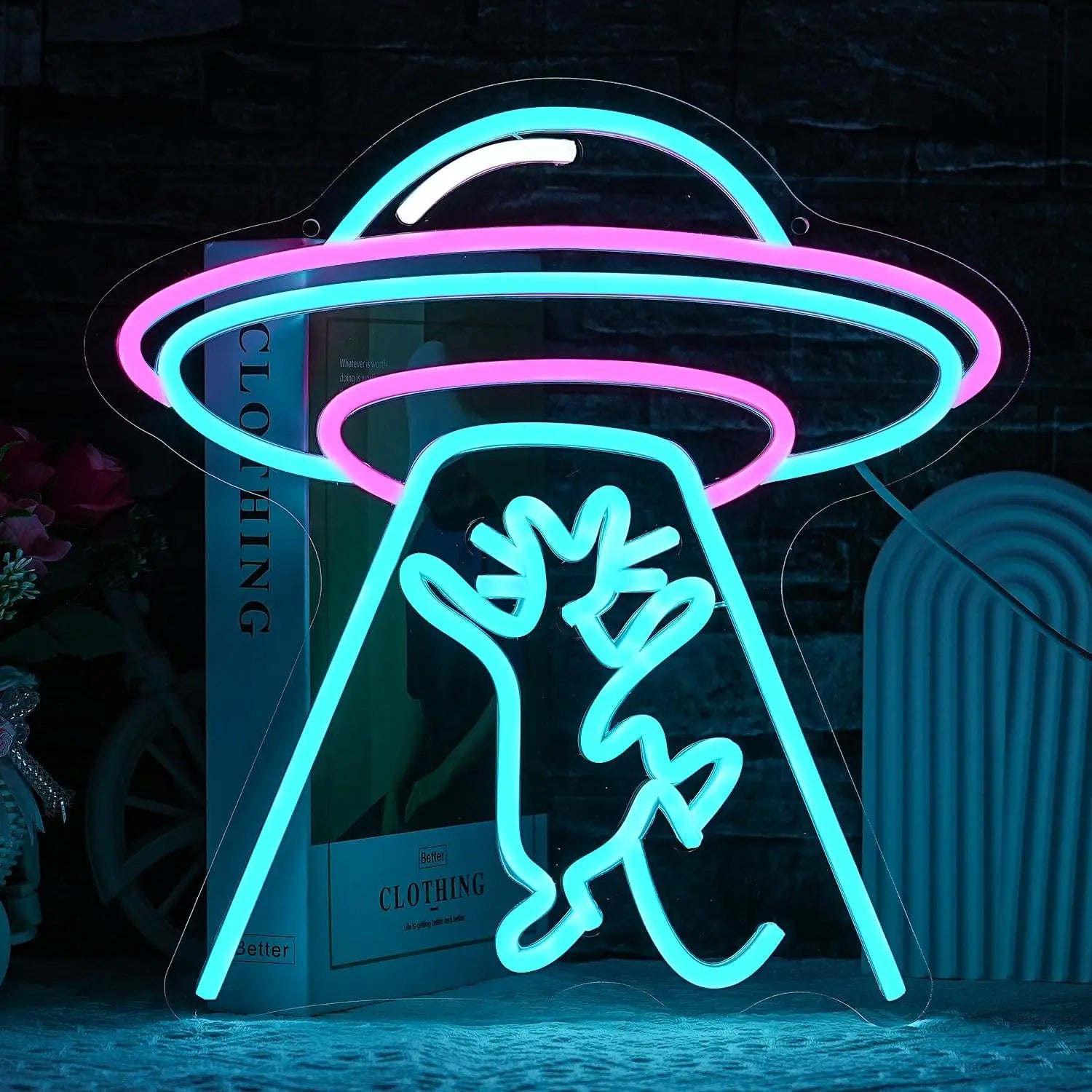 Vibrant neon sign of a UFO abducting a cat, glowing in pink, blue, and white hues.