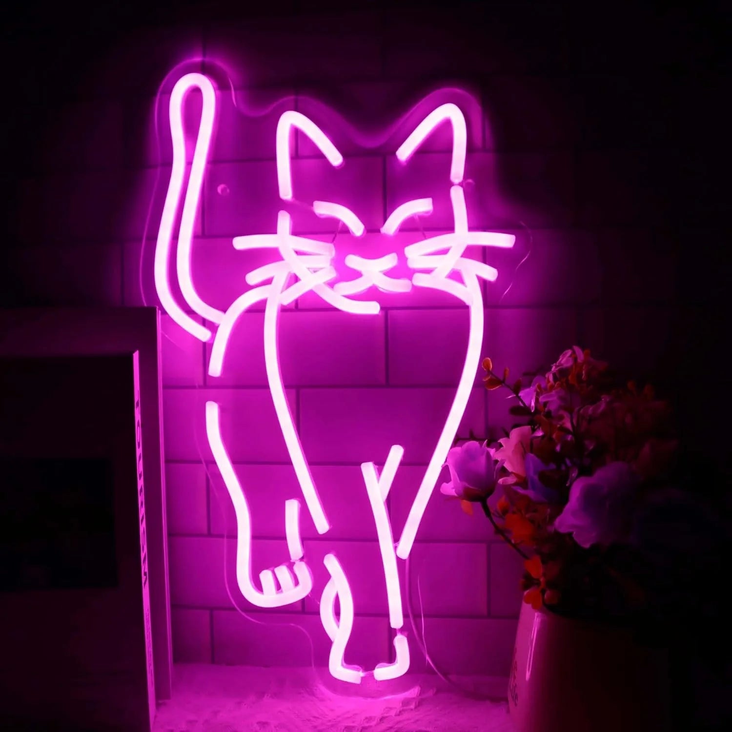 Close-up of a glowing pink LED cat-shaped neon sign against a tiled wall, showcasing its sleek design and warm glow.